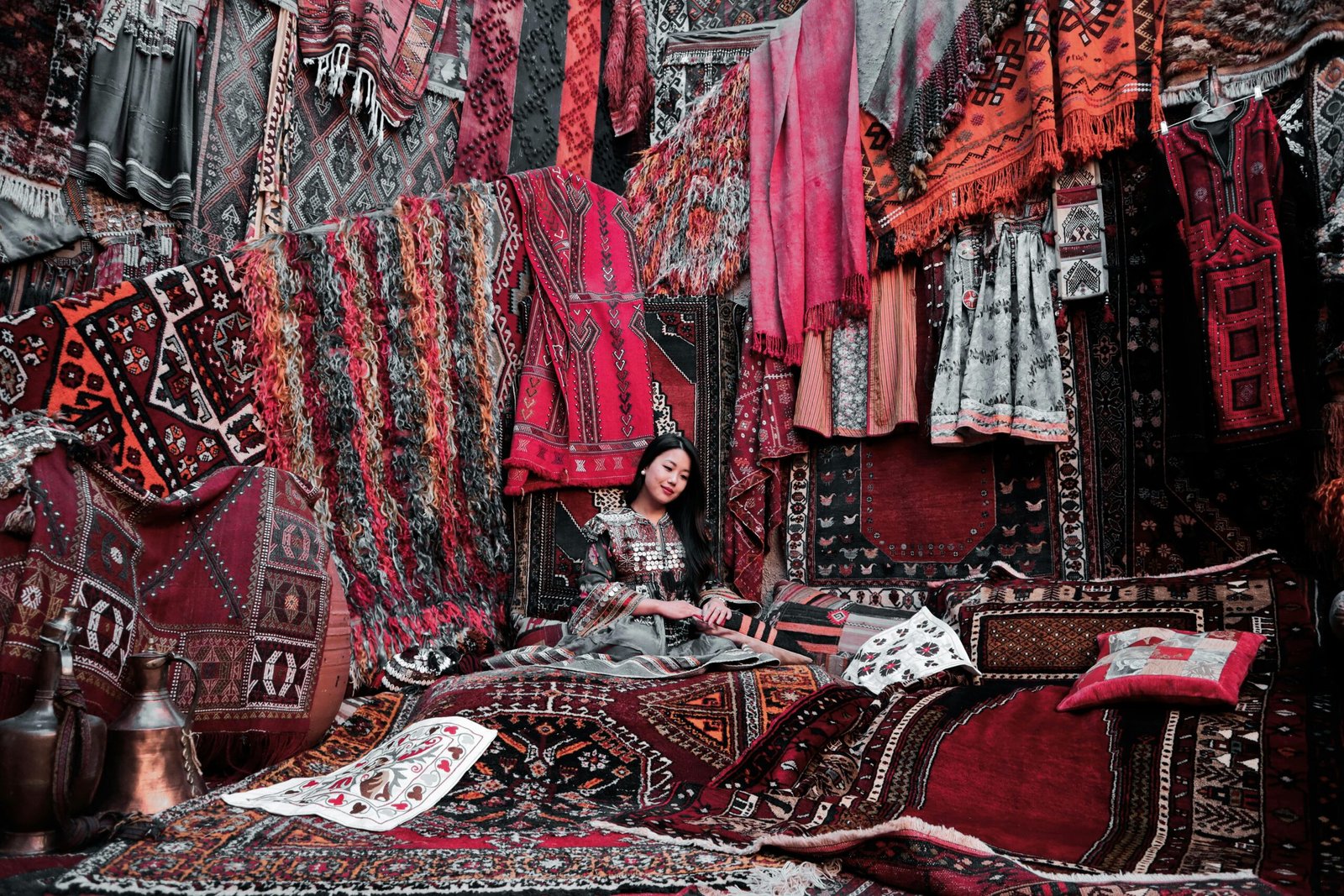 A vibrant display of traditional Turkish rugs and textiles in an indoor market.